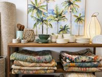 Mediterranean home decoration with colourful vintage kilim rugs, ceramic tableware, woven textures and tropical artwork in a rel Mediterranean home decoration with colourful vintage kilim rugs, ceramic tableware, woven textures and tropical artwork in a rel