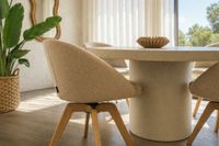 round concrete dining table with swivel upholstered chair in mediterranean interior mallorca with natural light