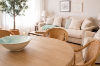 Relaxed Mediterranean living room at Palma Tennis Club with warm wood furniture, natural textures, rattan dining chairs and soft Relaxed Mediterranean living room at Palma Tennis Club with warm wood furniture, natural textures, rattan dining chairs and soft