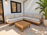 Outdoor lounge area of a Santa Catalina penthouse with teak sofa, neutral cushions and Mediterranean patterned tiles.
