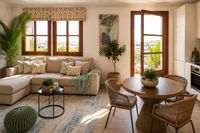 Bright open-plan living and dining space in Palma Old Town with Mediterranean styling, round wooden dining table, woven chairs and relaxed natural textures on Mallorca.