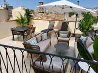 Rooftop penthouse terrace in Palma Old Town with outdoor lounge, dining area and Mediterranean city views designed for relaxed o