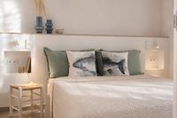Low guest bedroom bed in a Santa Catalina townhouse in Palma with soft Mediterranean styling, natural textures, warm neutral tones and relaxed ambient lighting.